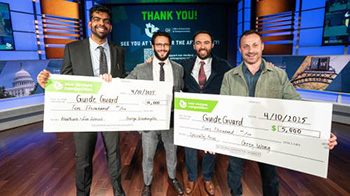 Four men pose for photos with large checks