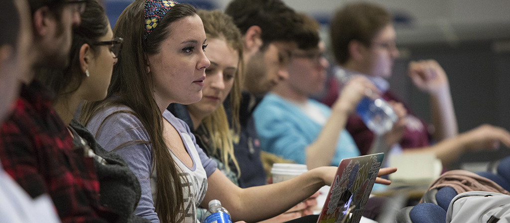 Students in class, raising a question.