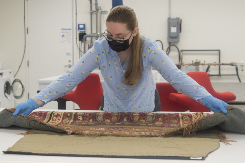Emma Cieslik, an MA student in the GW Museum Studies program, prepares an equestrian textile from the Brick Freedman Collection 