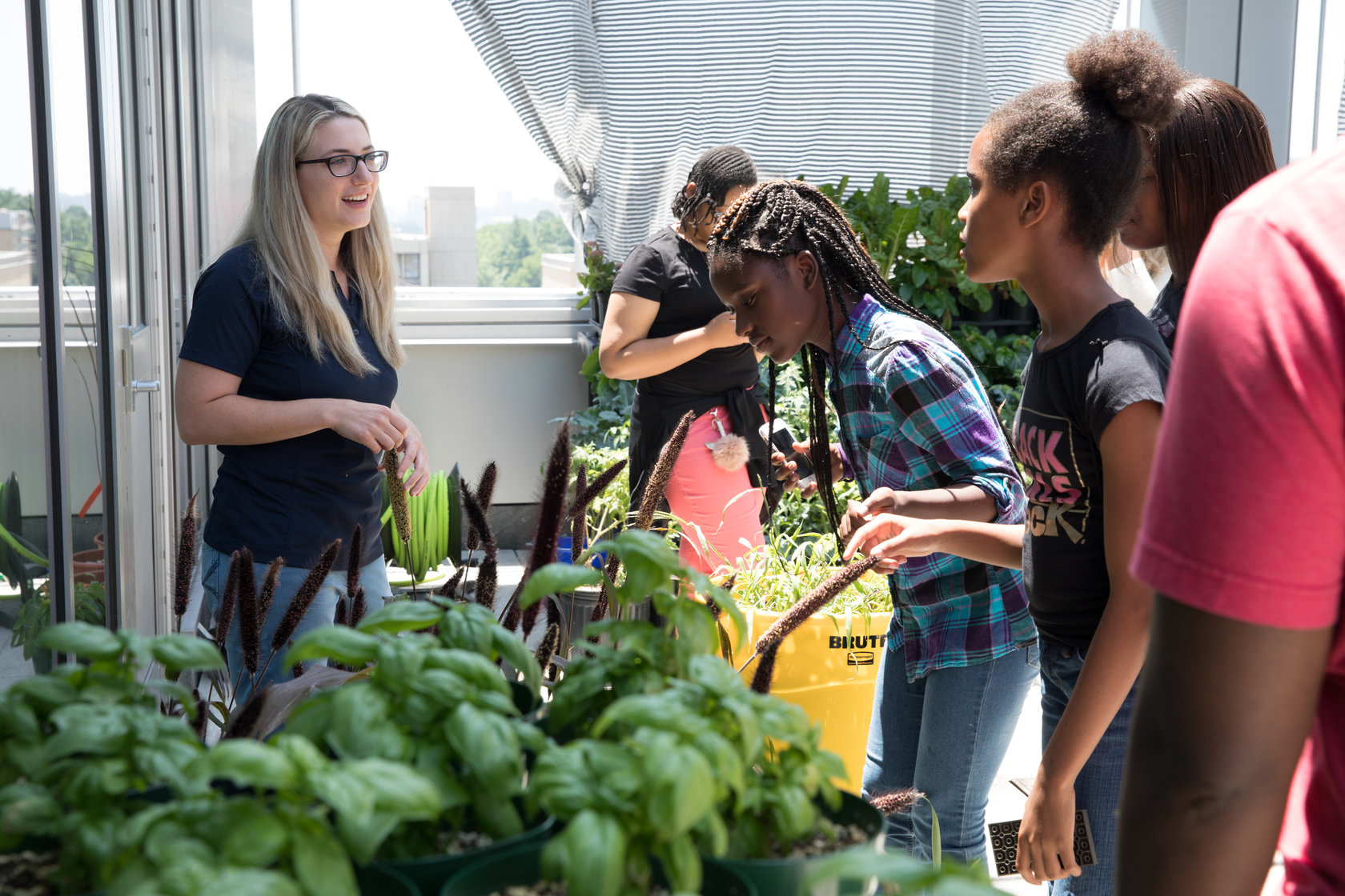 Greenhouse manager Rachel Klein with students from Washington Middle School for Girls