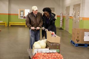 Steven V. Roberts (l) walks with the Store project coordinator Chinwendu Ngwadom to push a cart during a resupply run to Capital Area Food Bank.