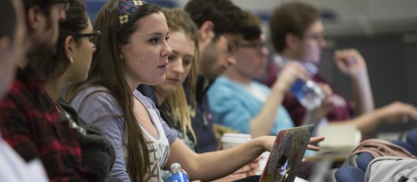 Students in class, raising a question.